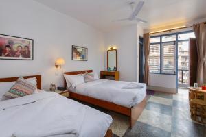 加德满都Pacific Guest House的酒店客房设有两张床和窗户。