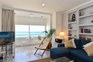 大加那利岛拉斯帕尔马斯拉斯坎特拉斯海滨公寓的客厅配有蓝色沙发,享有海景