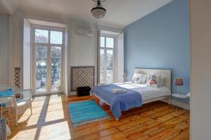 里斯本Lisbon Tejo Apartment Best Location with River View的一间拥有蓝色墙壁的卧室和一张铺有地毯的床
