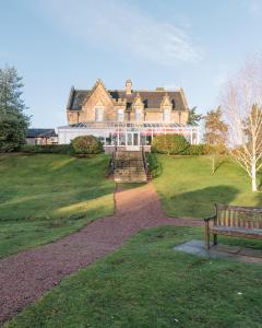 因弗内斯Inverness Lochardil House的坐落在郁郁葱葱的绿色田野上的大型房屋