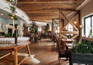 巴特布卢毛布鲁茂百水温泉大饭店的餐厅设有木制天花板和桌椅