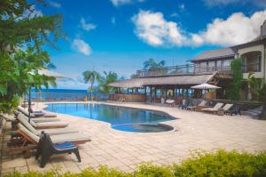 潘托皮芒日落礁石Spa度假村 的一个带躺椅的度假游泳池以及大海