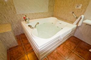 阿尔卡拉德瓜代拉安达卢西亚新旅馆的瓷砖浴室设有白色浴缸。