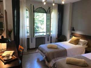 奥洛特Espectacular Casa Chateau en el centro de Olot的一间卧室设有两张床和窗户。