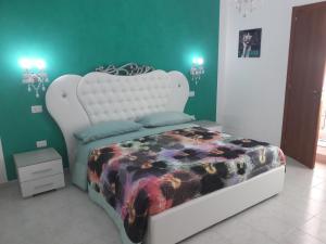 特罗佩阿B&B Romy的卧室配有白色床和花卉图案的毯子