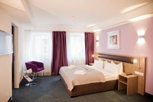 柏林尼古拉公寓酒店的酒店客房,配有一张床和一张紫色椅子