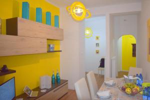 代森扎诺-德尔加达Red & Blu Apartments的一间设有桌子和黄色墙壁的餐厅