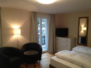 奥博奥多夫艾尔鹏豪弗兰德酒店餐厅的卧室配有床、椅子和窗户。
