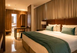 里约热内卢美洲巴拉酒店 的一间卧室配有一张大床和一张书桌