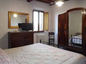 蒙特普齐亚诺CASA SERENA的一间卧室配有一张床、梳妆台和镜子