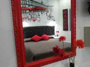 马德里劳里亚旅馆的客房内的红色镜子和床