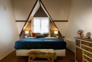 哈莱姆Haarlem Hotel Suites的一间卧室设有蓝色的床和窗户。