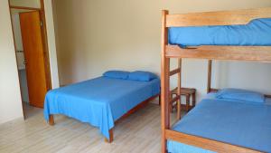 曼克拉Casamar的客房内的2张双层床,配有蓝色床单