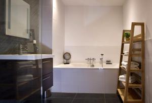 哈莱姆Haarlem Hotel Suites的浴室配有盥洗盆和浴缸。