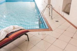 彭米斯伯恩林德霍夫胡梅尔斯伯格酒店的游泳池旁的游泳池,带椅子