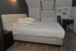 波佩林赫宫殿酒店的卧室内的一张带白色床单和枕头的床