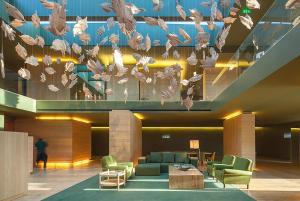 阿马兰特Monverde - Wine Experience Hotel - by Unlock Hotels的大堂设有桌椅和吊灯。
