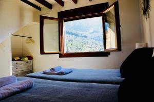 福纳卢奇Can Pera Accommodation - TI的一间卧室设有两张床和大窗户