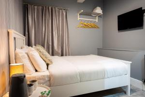 曼彻斯特REM酒店的卧室配有白色的床和电视。