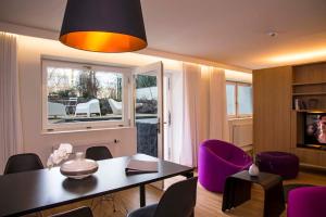 卢森堡凯帕克德梅尔公寓酒店的客厅配有桌子和紫色椅子