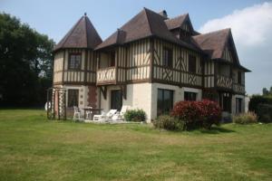 Saint-Étienne-la-Thillaye梅非庄园住宿加早餐旅馆的田野上带 ⁇ 顶的大房子