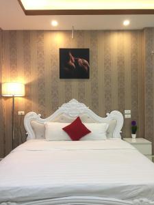 内排HD酒店的卧室配有白色的床和红色枕头