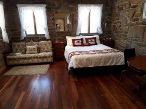 Springton1860酒乡小屋住宿加早餐旅馆的一间卧室配有一张床、一张沙发和窗户。