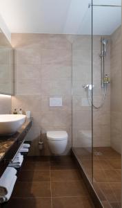 利斯塔尔巴德舒恩伯格酒店的一间带卫生间和玻璃淋浴间的浴室