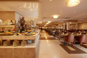麦地那Frontel Al Harithia Hotel的一间带桌椅的餐厅以及一间自助餐