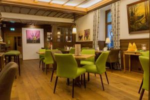 托特瑙Das Waldhotel - Genuss & Wellness am Notschreipass的一间带绿色椅子和桌子的餐厅