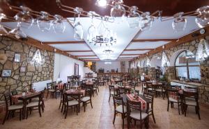 南埃福列Hanul Hora Romaneasca的一间在房间内配有桌椅的餐厅
