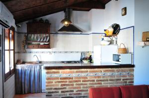 Zalamea la RealEl Romerito的厨房配有砖台和白色冰箱