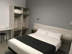 萨拉曼卡Hostal I Dream Salamanca的一间卧室配有带白色床单和架子的床