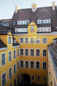 莱比锡弗雷格豪斯酒店的黄色建筑,有白色的窗户和屋顶
