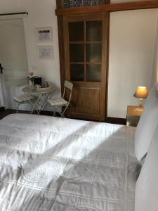 吉维尼Rose Garden Mezzanine的卧室配有一张白色的大床和一张桌子