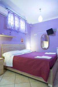 那不勒斯Campi Flegrei House的一间卧室配有一张带紫色墙壁和镜子的床