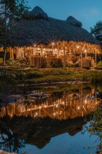 El ValleEl Valle Lodge的夜间在水中反射的小屋