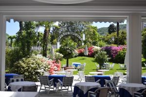 斯特雷萨皇家酒店的户外用餐区设有桌椅和鲜花