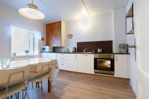 ÞingeyjarsveitOriginal North的厨房配有白色橱柜、桌子和壁炉。