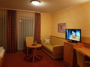 凯撒斯劳滕福利池酒店及餐厅的带沙发和电视的客厅