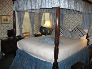 剑桥A Cambridge House Inn的卧室配有一张带白色床罩的天蓬床