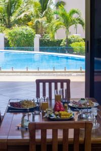迪亚尼海滩Seaclusion Diani的游泳池旁的餐桌上放着食物