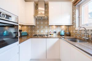 爱丁堡皇后区美景公寓的厨房配有白色橱柜和水槽
