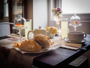 科维良Memórias Charme Residences的桌上放有面包、咖啡和牛奶