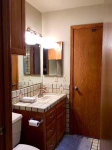 奥克赫斯特Kin House Guest Suite的一间带水槽、卫生间和镜子的浴室