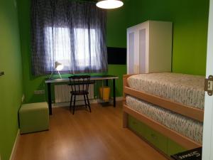 CobisaCasa La Rosa de los Vientos的一间卧室设有绿色的墙壁、一张床和一张书桌