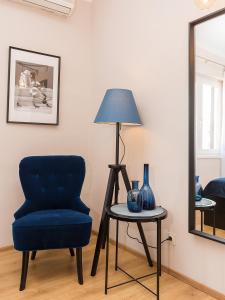 波雷奇New City Center Design Apartment的一间设有蓝色椅子和一张带台灯的桌子的房间