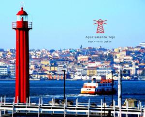 CacilhasApartamento Tejo的红灯塔和水中的船