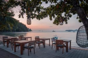 攀瓦海滩科夫住宿加早餐旅馆的一组桌子和椅子在水边