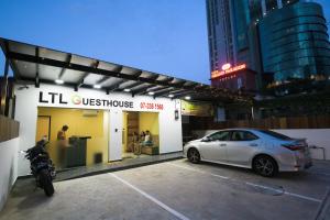 新山LTL Guesthouse的停在商店前的白色汽车